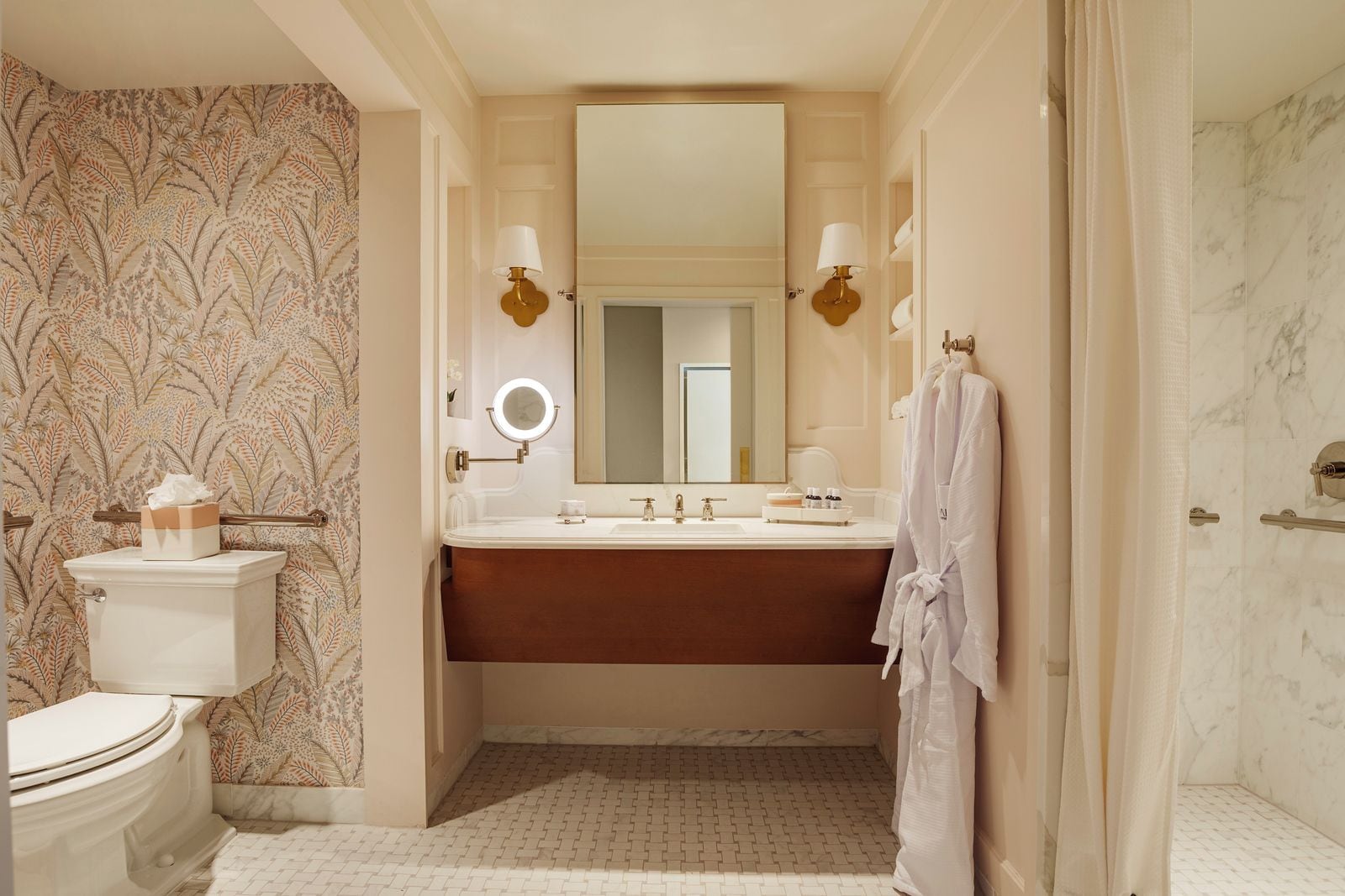 A bathroom with a toilet, sink, mirror, and shower area.