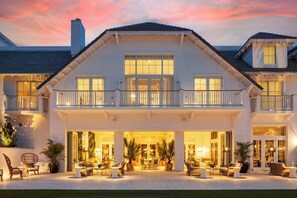 A large, multi-story house with a balcony, large windows, and an outdoor seating area with furniture. - Olde Naples Hotel (Naples)