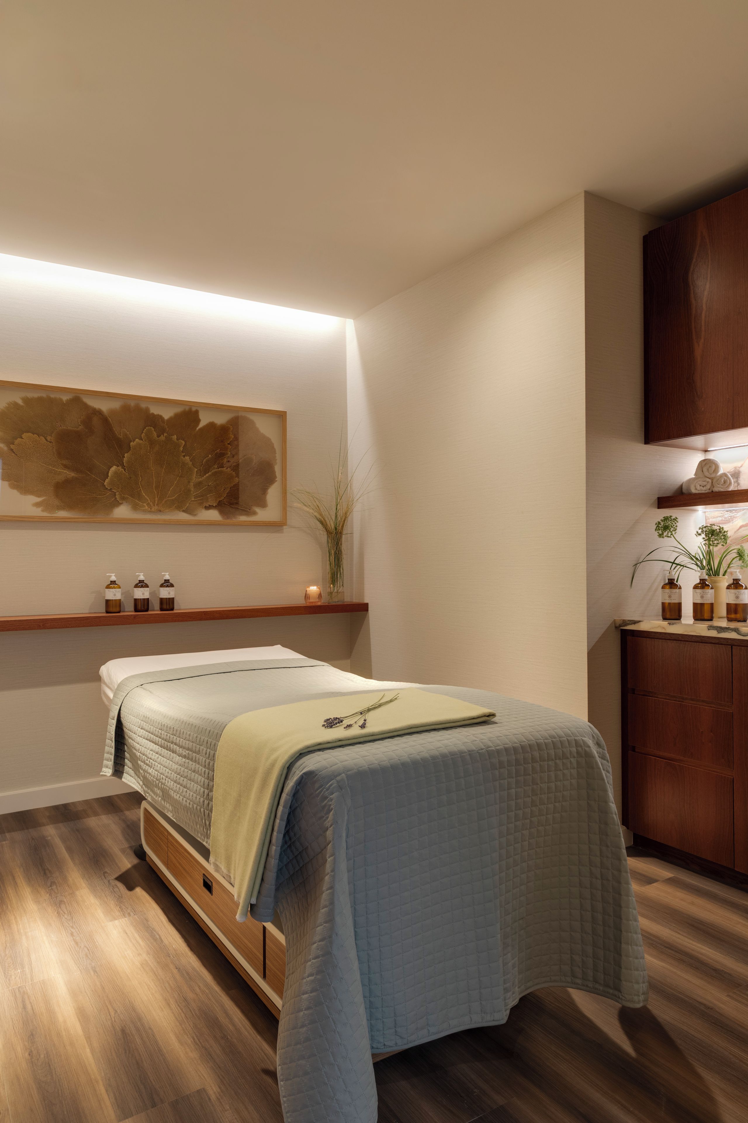 Une chambre à coucher bien rangée, avec un lit, des tables de chevet et une étagère fixée au mur.