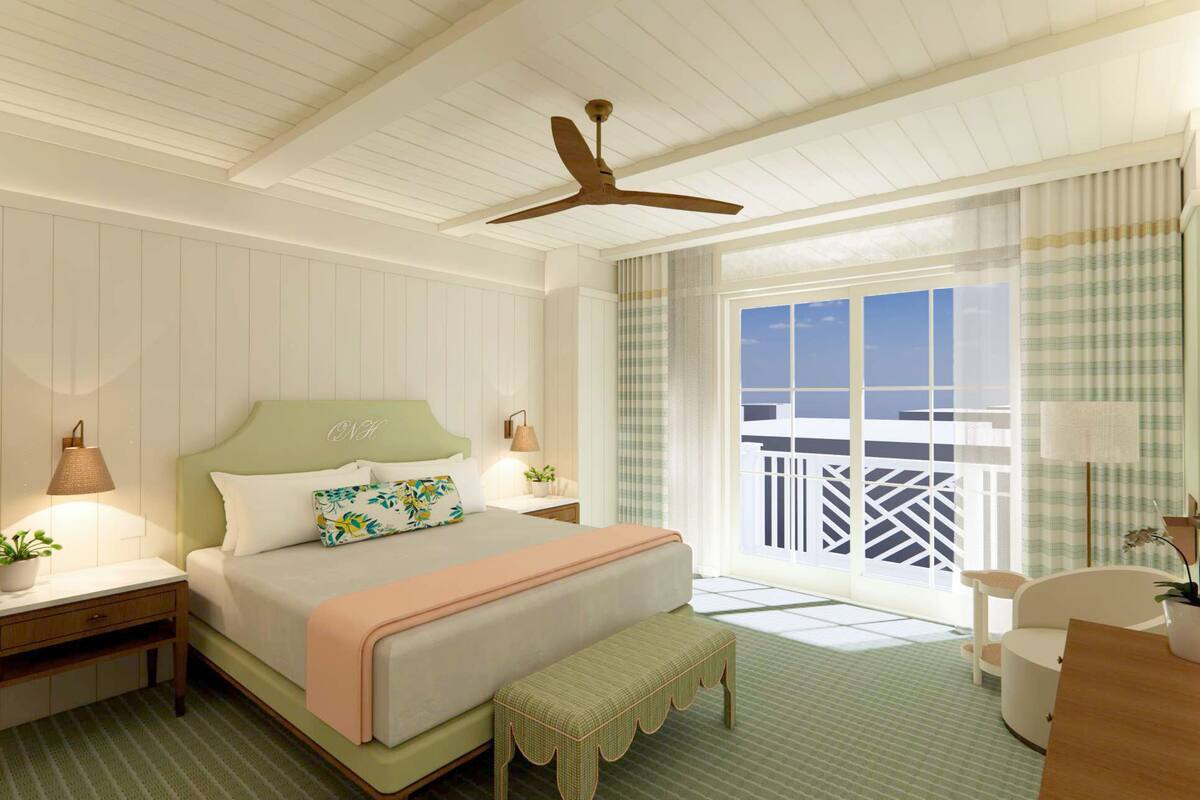 A hotel room with a bed, bedside tables, a desk, a chair, a ceiling fan, and a balcony with a view.