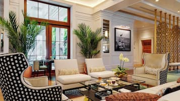 A spacious living room with a large window, two sofas, a coffee table, and decorative plants.