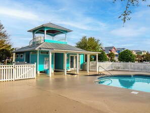 Une tour de surveillance turquoise, dotée d’un balcon, d’un espace de repos couvert et d’une piscine.