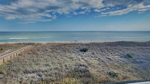 A beach with a wooden boardwalk leading to the shore, sandy dunes, and a clear sky. - Winds V1 #3B - My Top Paradise (Carolina Beach)