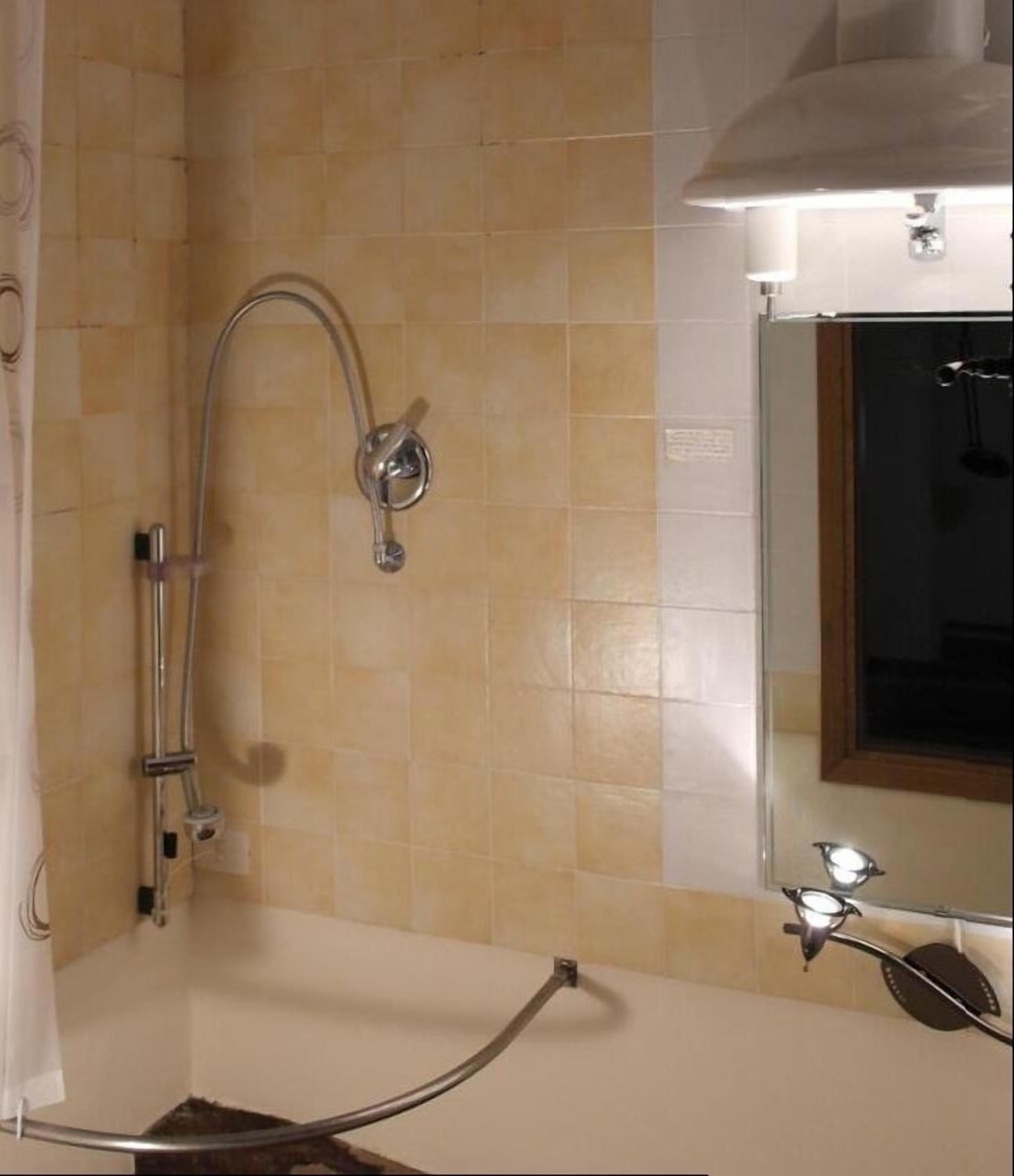 Un baño con ducha, bañera y espejo.