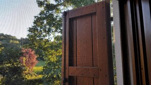 A wooden door with a mesh screen, likely leading to a balcony or outdoor area. - Ai Chiosi (Pontremoli)