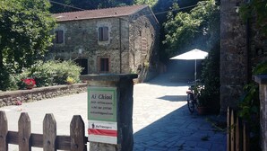 A stone building with a signboard indicating 'Ai Chiossi' and contact information. - Ai Chiosi (Pontremoli)