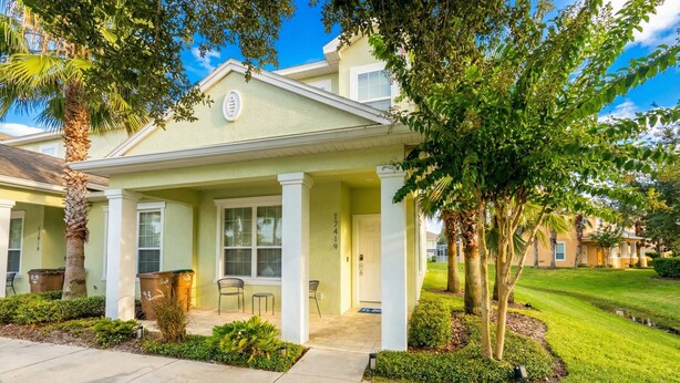 A residential building with a front porch, a door, and a small garden area. - 3BR Home w/ Pool Near Disney (Clermont)