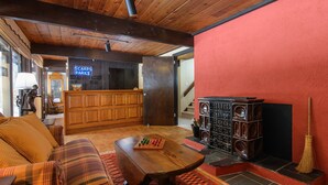 A cozy living area with a plaid sofa, a wooden coffee table, and a fireplace. - Ski, Hike & Explore-Waitsfield Retreat Near Sugarbush (Waitsfield)