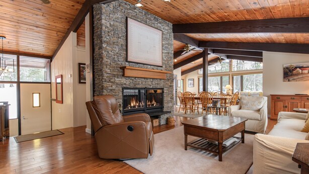 A spacious living room with a stone fireplace, wooden ceiling beams, and a comfortable seating area. - Ski, Hike & Explore-Waitsfield Retreat Near Sugarbush (Waitsfield)