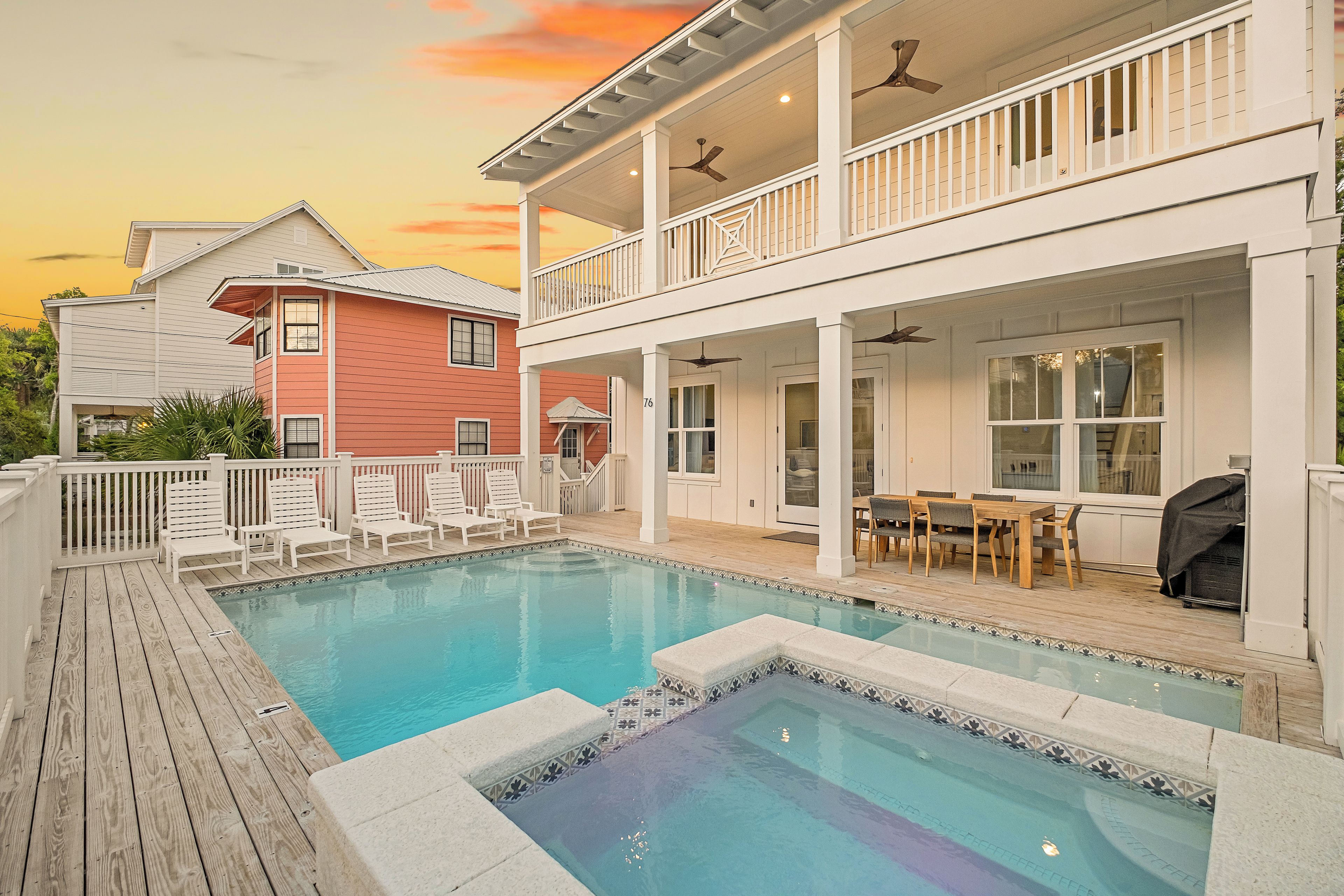 A two-story house with a pool, a covered patio, and a dining area.
