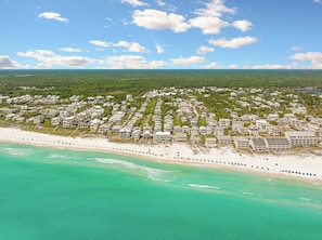 An aerial view of a coastal residential area with beachfront properties, dense greenery, and a clear sky. - Sunny Side Up | Private Pool/Spa | 6-Seater Golf Cart | Walk to Beach (Santa Rosa Beach)
