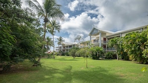 A hotel with multiple floors, surrounded by lush greenery and palm trees. - Le Ti Mahogany - Studio avec Balcon (Saint-Francois)