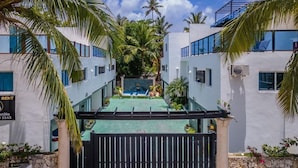 A gated resort with a pool, palm trees, and a clear blue sky. - Luxury villa with Jacuzzi and BBQ 150 meters from the beach (Punta Cana)