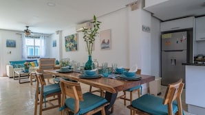A dining area with a wooden table set for six, surrounded by chairs with teal cushions. - Luxury villa with Jacuzzi and BBQ 150 meters from the beach (Punta Cana)