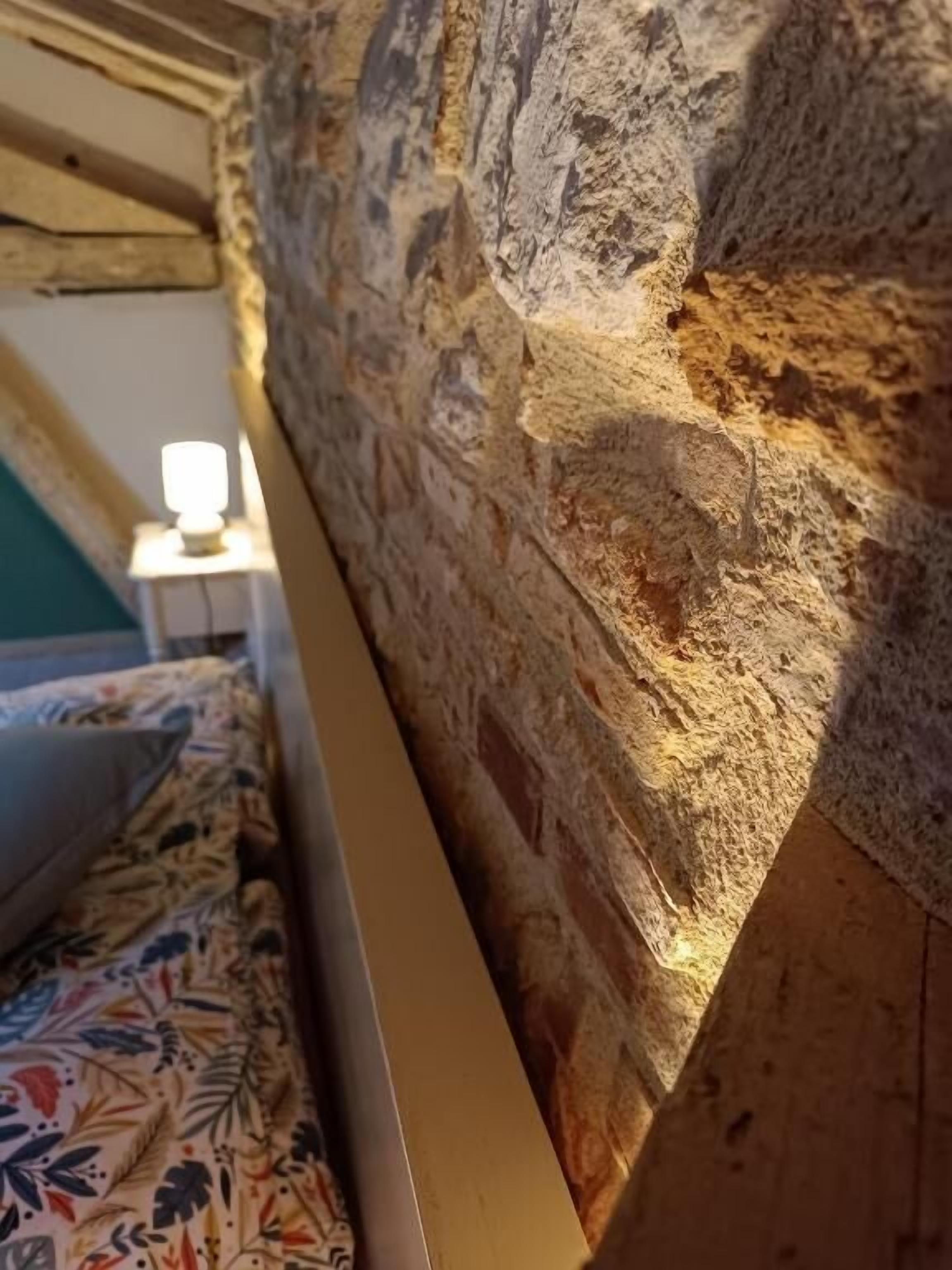 A room with a stone wall and a wooden beam.