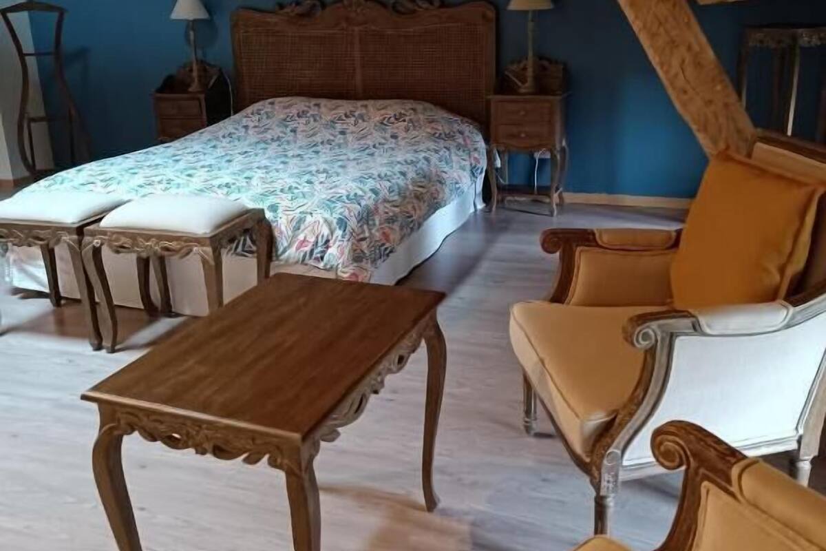 Ein Schlafzimmer mit einem Bett, zwei Nachttischen, einem Holztisch und zwei Stühlen.