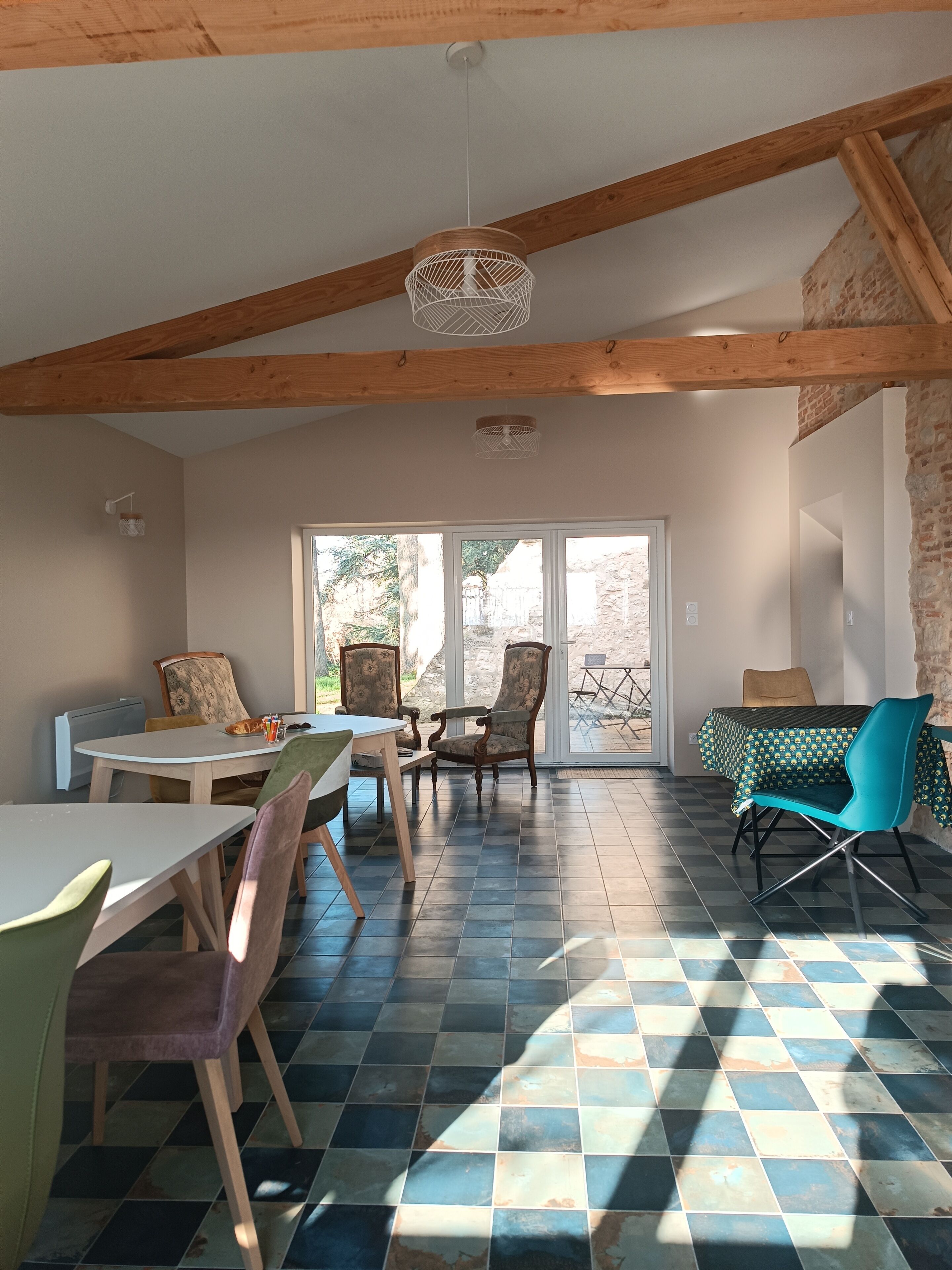 A dining area with a checkered floor, wooden beams, and a table with chairs.