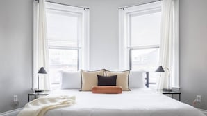 A bedroom with a bed, two bedside tables, and a window with blinds. - Luxury Home located in Back Bay 8min walk to Fewnway Park, close to Boston University, Berklee & MIT (Boston)