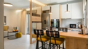 Een moderne keuken met een houten kookeiland, barstoelen en een eethoek.