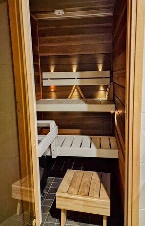 A sauna with wooden benches and a small wooden table.