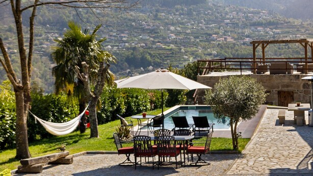 A pool area with outdoor seating, a hammock, and a view of a valley. - Holiday Home 'Quinta do Rio Douro - Rural Tourism' with Mountain View, Pool and AC (Douro)