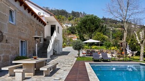 A stone building with a pool, outdoor seating, and a staircase leading to a second floor. - Holiday Home 'Quinta do Rio Douro - Rural Tourism' with Mountain View, Pool and AC (Douro)
