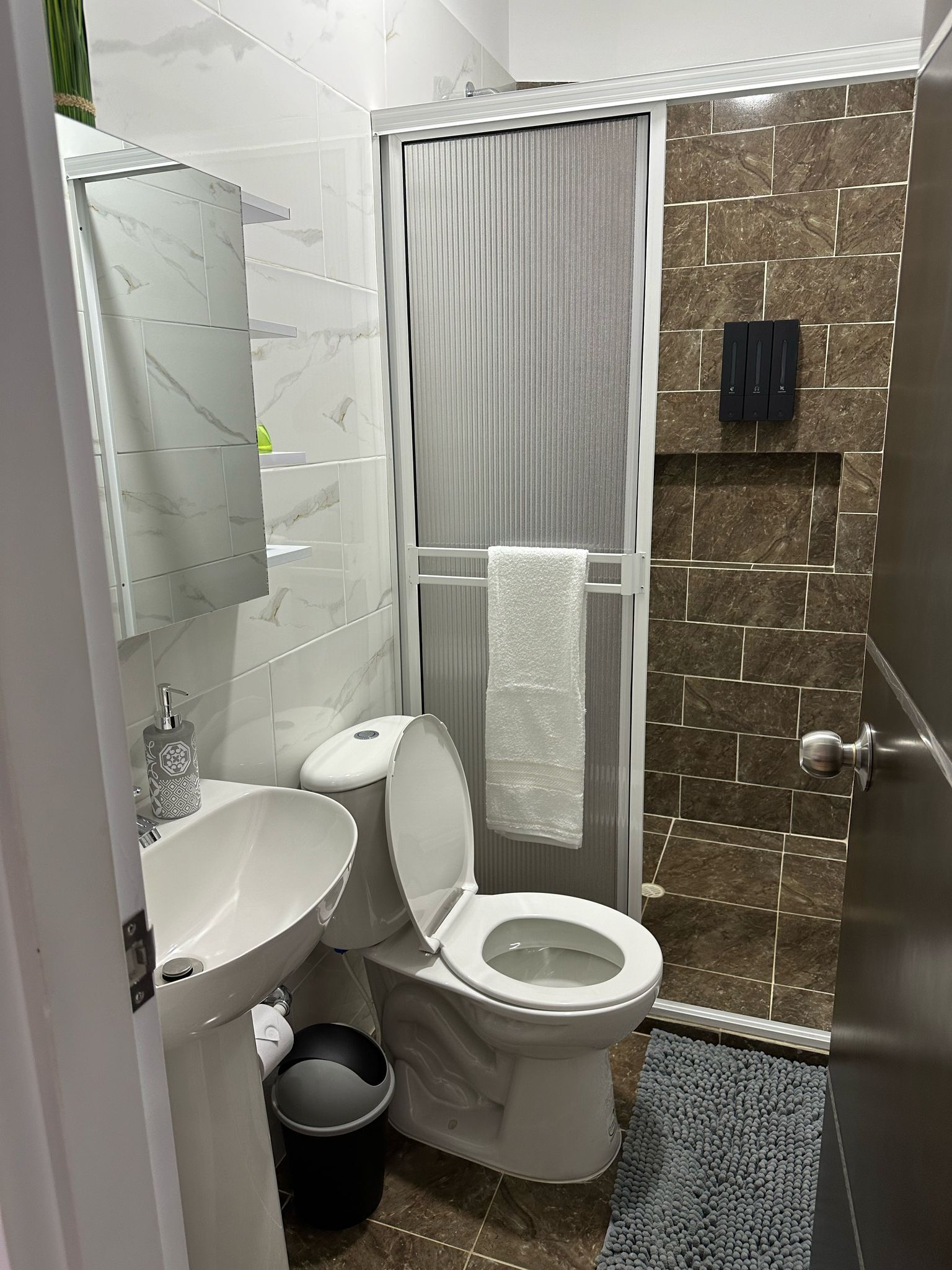 Ein kleines Badezimmer mit Toilette, Waschbecken und Duschbereich.