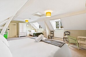 A bedroom with a large bed, a window, a radiator, and a chair. - Huckleberry Farm House (Goring)