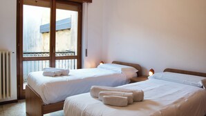Een hotelkamer met twee bedden, een raam met uitzicht en een radiator.