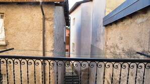 Un callejón estrecho con una reja metálica y una escalera que lleva a un edificio.