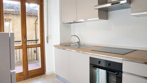 Cocina con encimera de madera, pileta de acero inoxidable y lavavajillas.