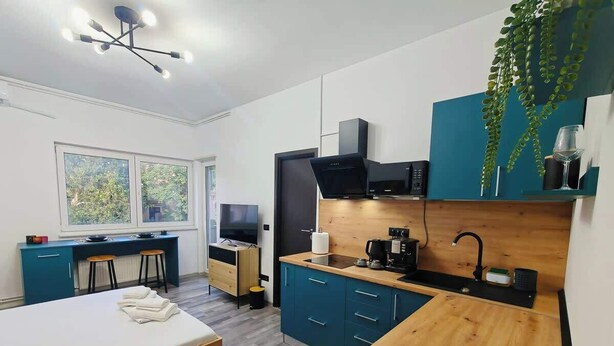 Ein modernes Schlafzimmer mit Bett, Schreibtisch und einer Küchenzeile.