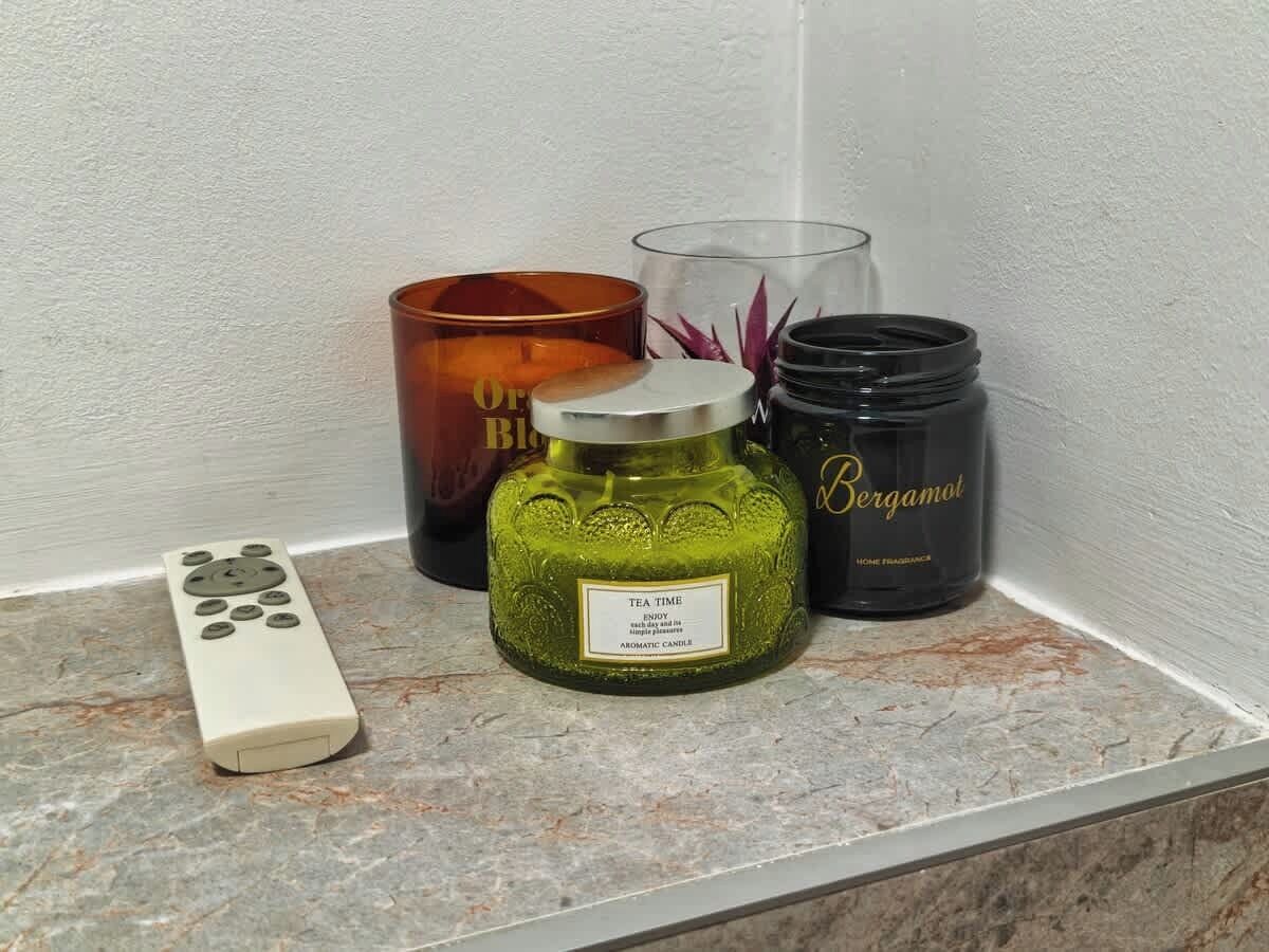 En fjernbetjening, et grønt lys med teksten 'TEATID', og to lys med etiket 'Bergamot' på hver.