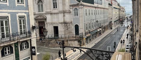 Vista de una calle con edificios de arquitectura tradicional, una senda peatonal y un farol.