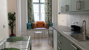 A modern kitchen with a built-in oven, a sink, and a window with curtains. - Lisbon Heart (Lisbon)