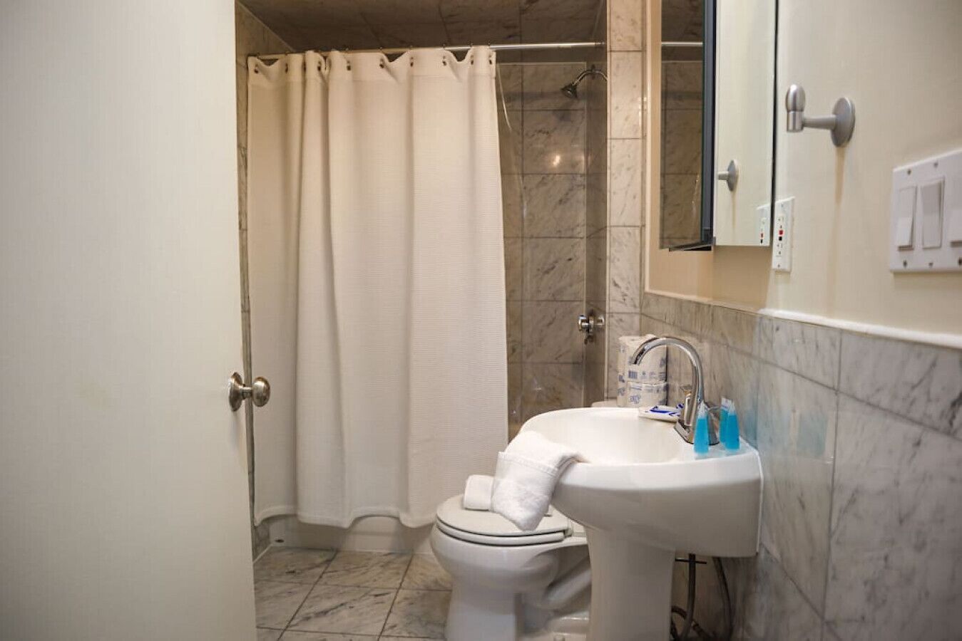 A bathroom with a toilet, sink, and shower.