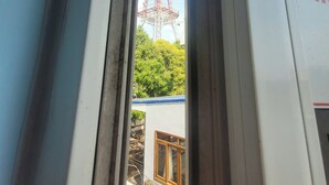Vista a través de una ventana que muestra un edificio con una estructura metálica en el fondo.