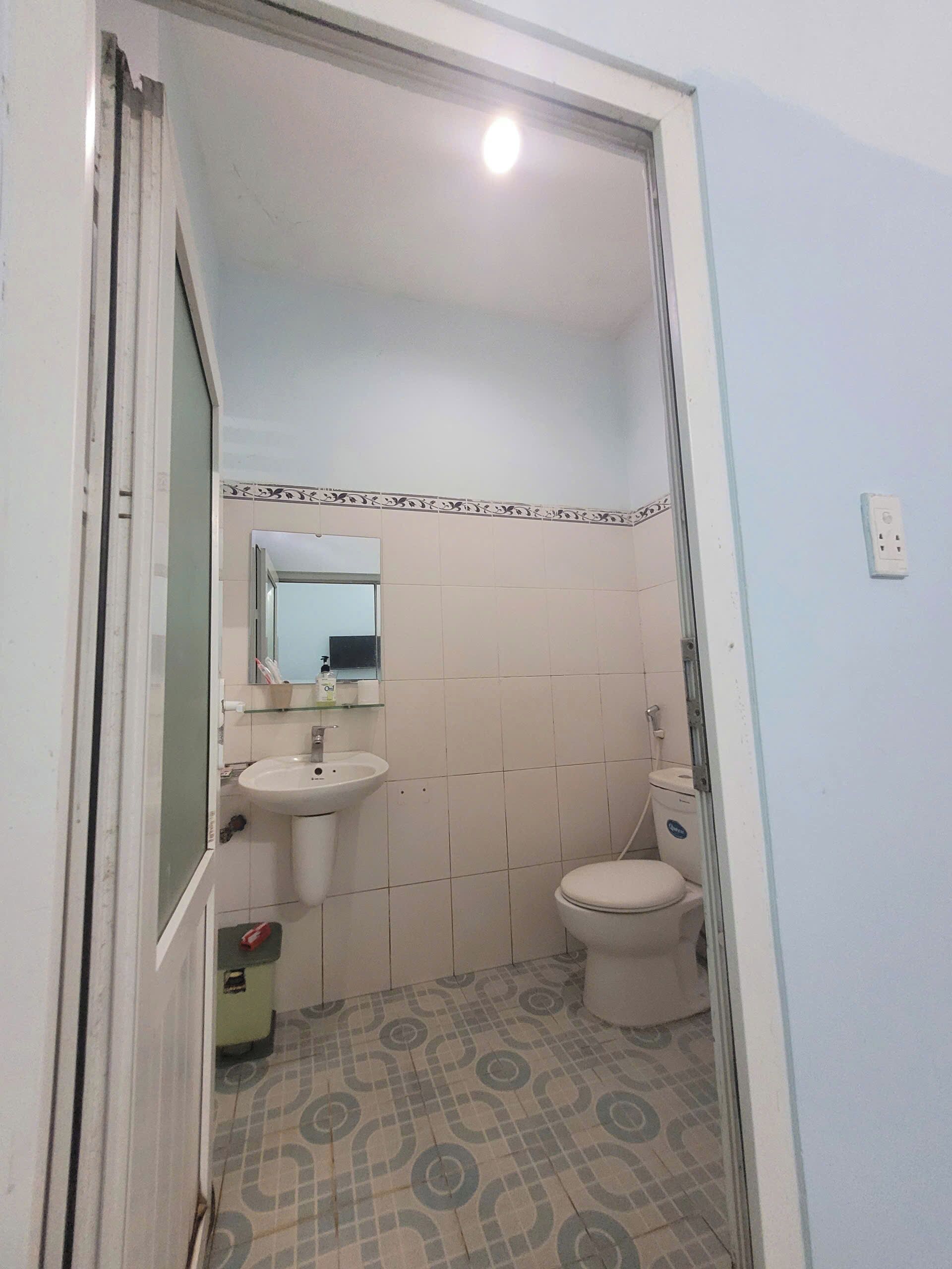 A bathroom with a sink, toilet, and mirror.