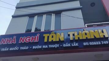 A building with a sign that reads "NHÃ NGHÌ TÃN THÃNH" and a phone number "02623 749".