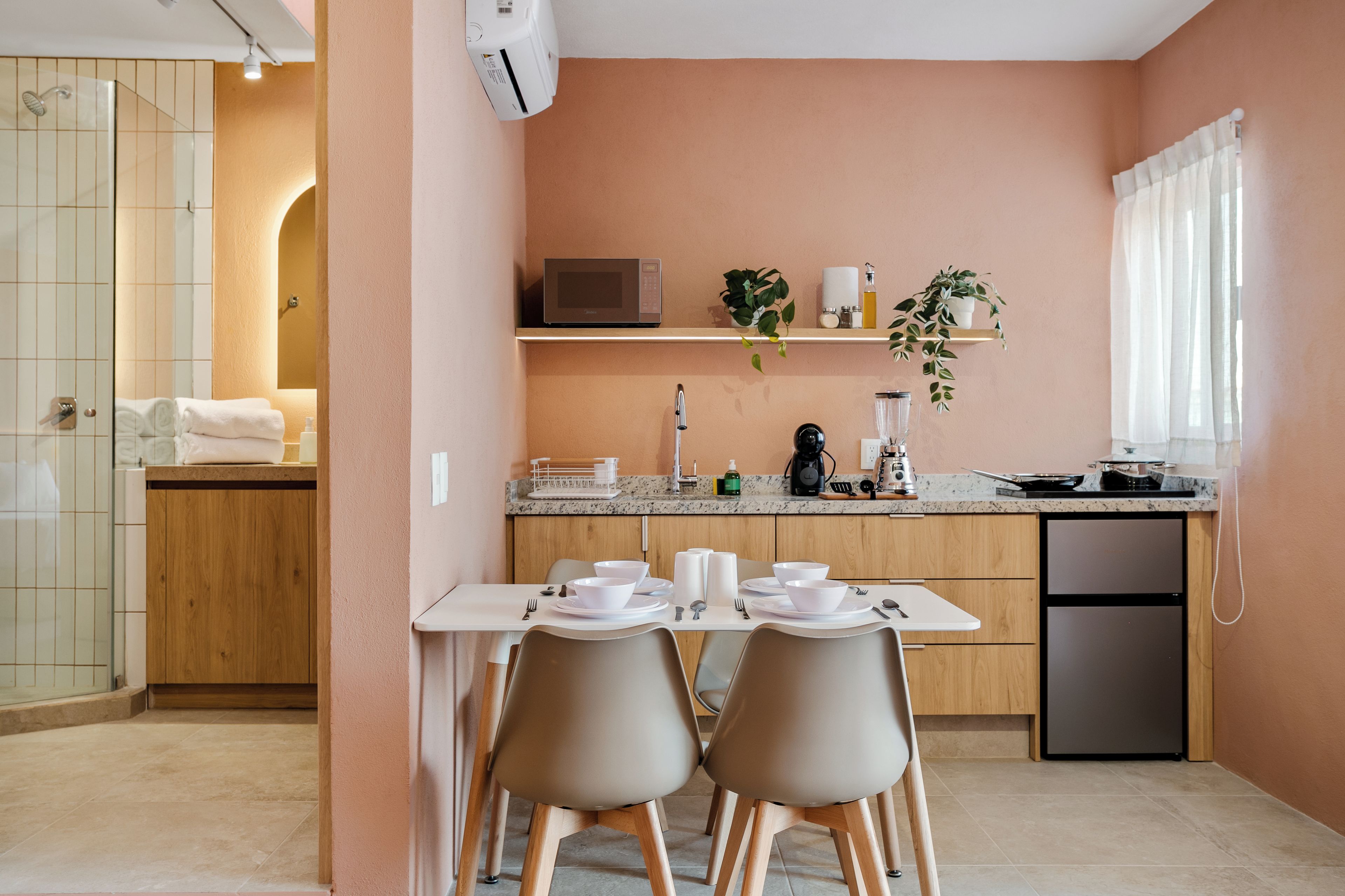 Cozinha moderna com área de jantar, com micro-ondas, pia e diversos eletrodomésticos.