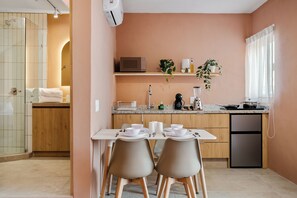 A modern kitchen with a dining area, featuring a microwave, sink, and various kitchen appliances. - Damián Carmona by Homirent (Queretaro)