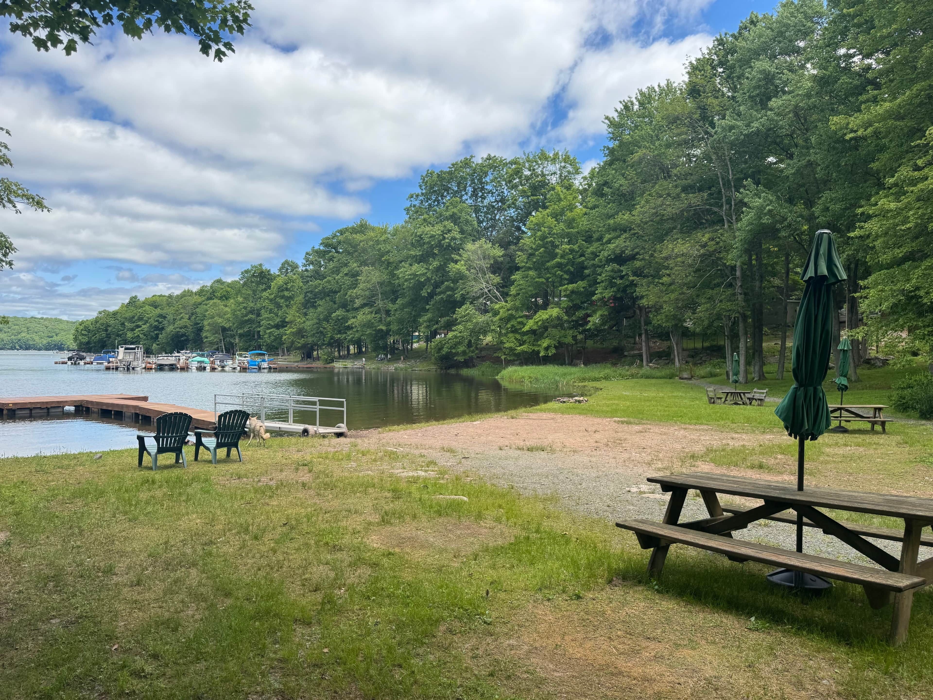 Un espace de pique-nique au bord du lac, équipé d’une jetée, de chaises et d’une table de pique-nique.