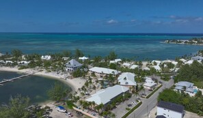 Ein Luftbild eines Küstenresorts mit Strandhäusern, einem Steg und klarem, blauem Wasser.