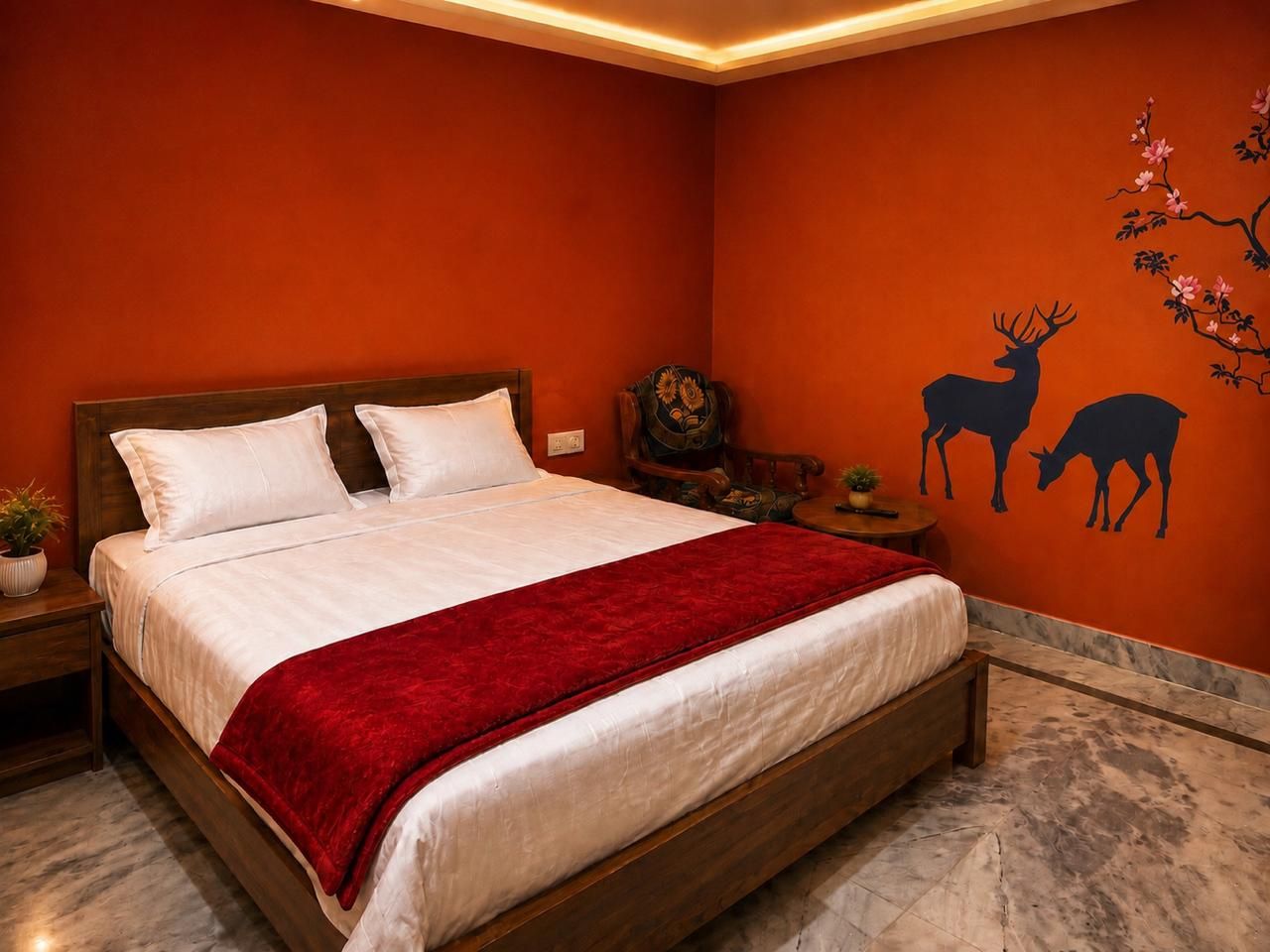 Una habitación con una cama, una mesita de noche, una pequeña mesa y un mural de un ciervo en la pared.