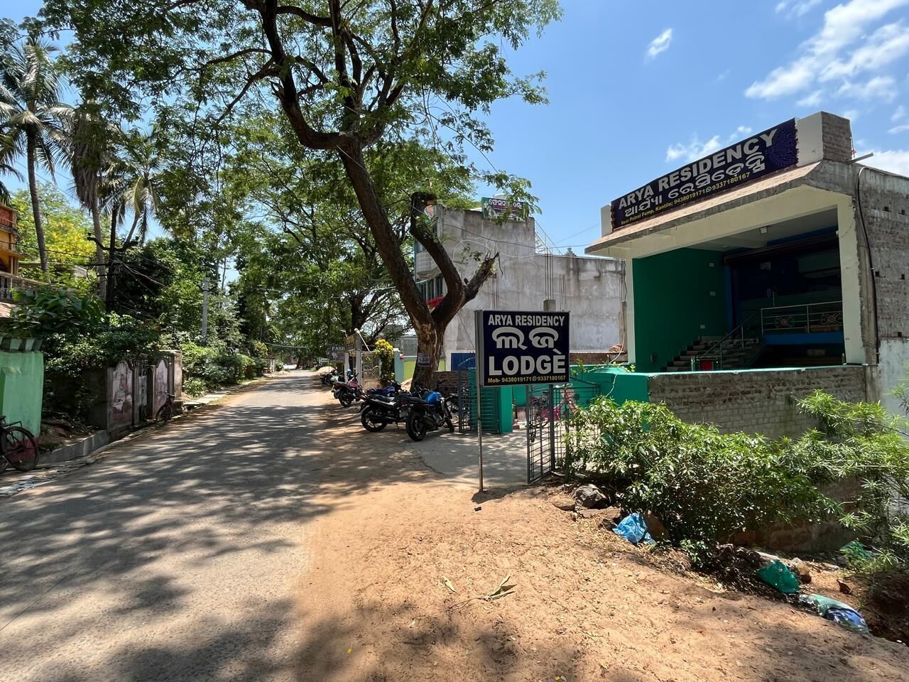 A residential area with a sign for 'Arya Residency Lodge.'