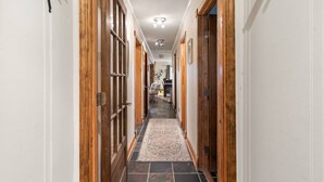 A hallway with wooden doors, a patterned rug, and a tiled floor. - Summit 104D Beautiful 3BR, 2BA condo in The Summit at Snowshoe (Snowshoe)