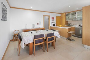 A compact kitchen with a dining area, wooden cabinets, and a small island. - Apartment 'Quinta Da Faya' with Sea View, Balcony and Wi-Fi (Angra do Heroísmo)