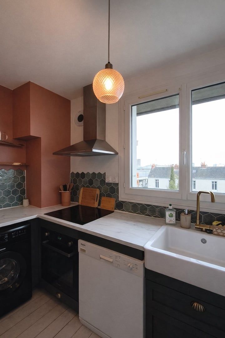 Een moderne keuken met een groot raam, een inbouwoven, een vaatwasser en een hanglamp.