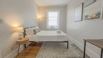 Escritorio, tabla de planchar con plancha, wifi y ropa de cama