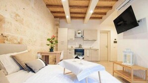 A bedroom with a bed, bedside table, and a TV mounted on the wall. - Urban Flat Garibaldi 36 (Bari)